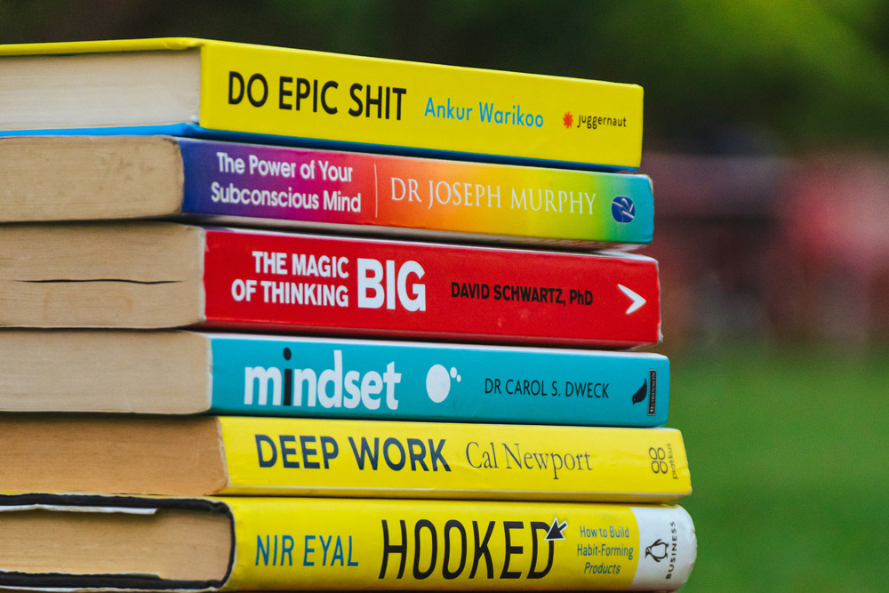 Imagem representativa com uma pilha de livros com objetivo de representar conteúdos sobre Inteligencia Artificial Livro